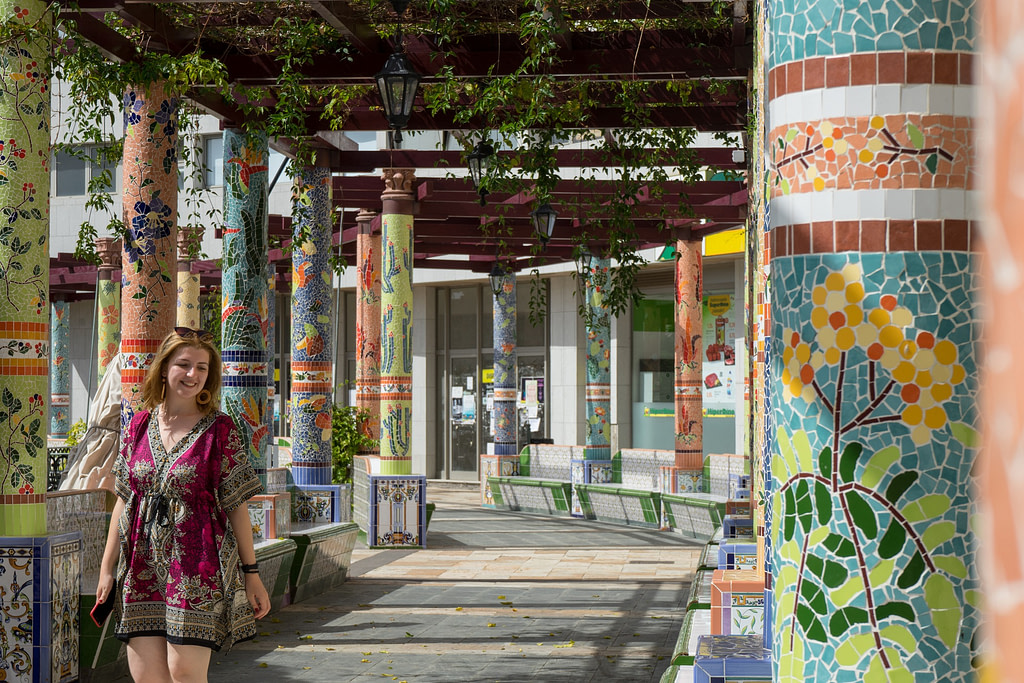 Classical tiled artistic spanish corridor with column in garden square. Art design attraction in landmark. Tile pillar in plaza